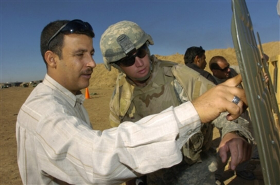 U.S. Army Spc. Thomas Couch and an Iraqi police officer view the officer's target during special weapons and tactics training at Forward Operating Base McHenry, Iraq, Nov. 22, 2006. International police liason officers and U.S. Army soldiers with 2nd Battalion, 300th Field Artillery Brigade are conducting the training. 