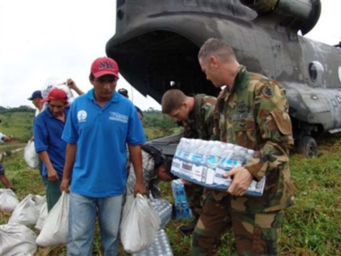 U.S. Army Chief Warrant Officer David Doig (right), U.S. Air Force Tech. Sgt. Vincent Codispoti and local citizens unload relief supplies from a CH-47 Chinook helicopter in Cocle, Panama, on Nov. 28, 2006.  U.S. military personnel from Soto Cano Air Base, Honduras, deployed to the area to provide assistance at the request of the Panamanian government.  