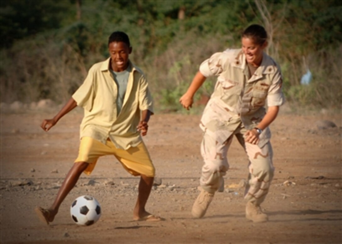 U.S. Navy Lt. Cmdr. Wendy Halsey, with Combined Joint Task Force-Horn of Africa, plays soccer with a Djiboutian boy at an orphanage in Djibouti City, Djibouti, on Nov. 20, 2006.  Halsey's friends and family collected more than 300 soccer balls from churches, schools and organizations throughout the United States for donation to schools and orphanages throughout the Horn of Africa.  