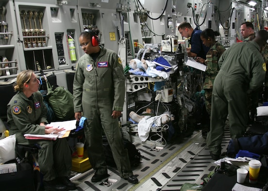 Crewmembers attend to patients aboard a C-17 Globemaster III at Hickam Air Force Base, Hawaii. Six sailors from the  USS Frank Cable were injured when a steamline burst while the sailors were conducting routine maintenance. (U.S. Air Force photo/Air Force Master Sgt. Roderick Reyes)