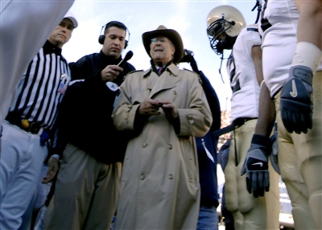 Defense Secretary Donald H. Rumsfeld, center, readies the coin toss during opening ceremonies for the 107th Army-Navy football game at Lincoln Financial Field in Philadelphia, Dec. 2, 2006.