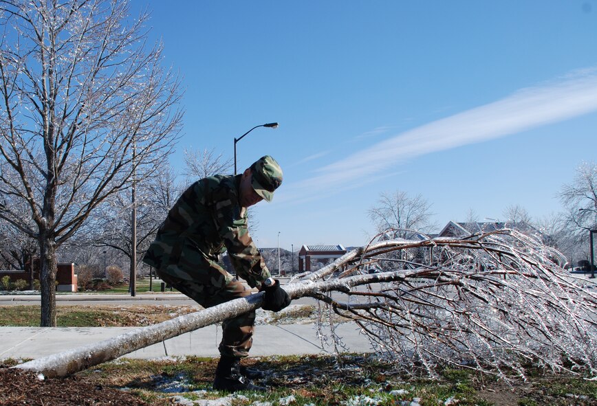 Weather changes the landscape around the base when freezing rain sticks to trees.  Tech Sgt. Daniel Oliver surveys the damage and does his part to move a damaged tree out of the way.