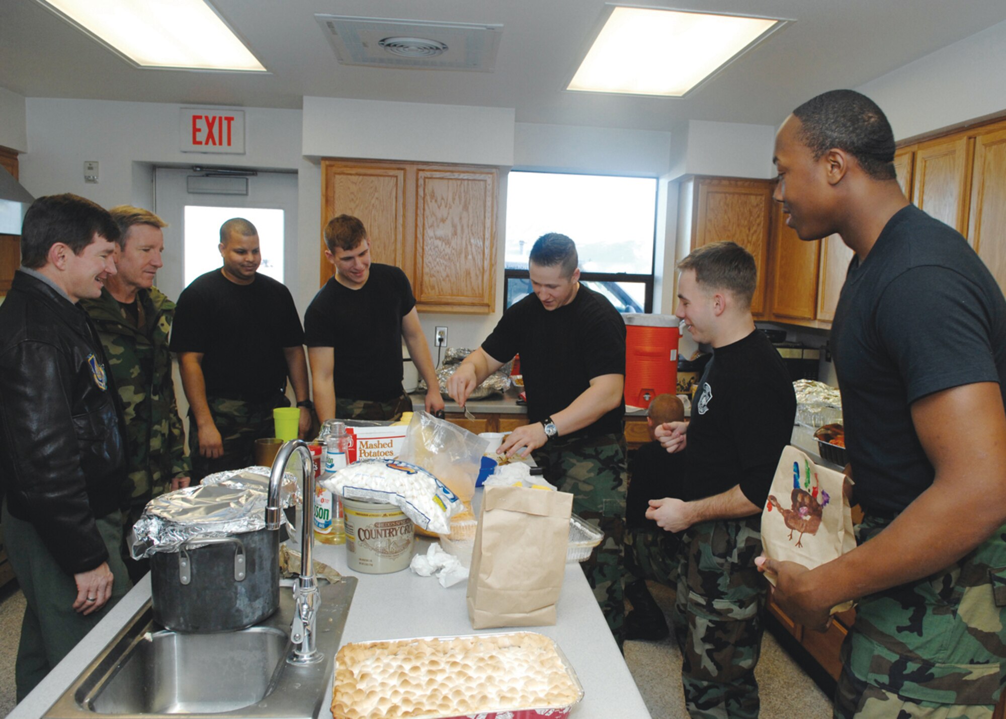 Staff Sgt. James Shultz, 3rd Civil Engineer Squadron, prepares Thanksgiving Dinner for Fire Station #1 as Brig. Gen. Hawk Carlisle, 3rd Wing commander, and Col. Scotty Lewis, 3rd Wing vice commander, stop in to drop off cookies and other goodies on Thanksgiving Day. 
(U.S. Air Force photo by Airman 1st Class Jonathan Steffan)