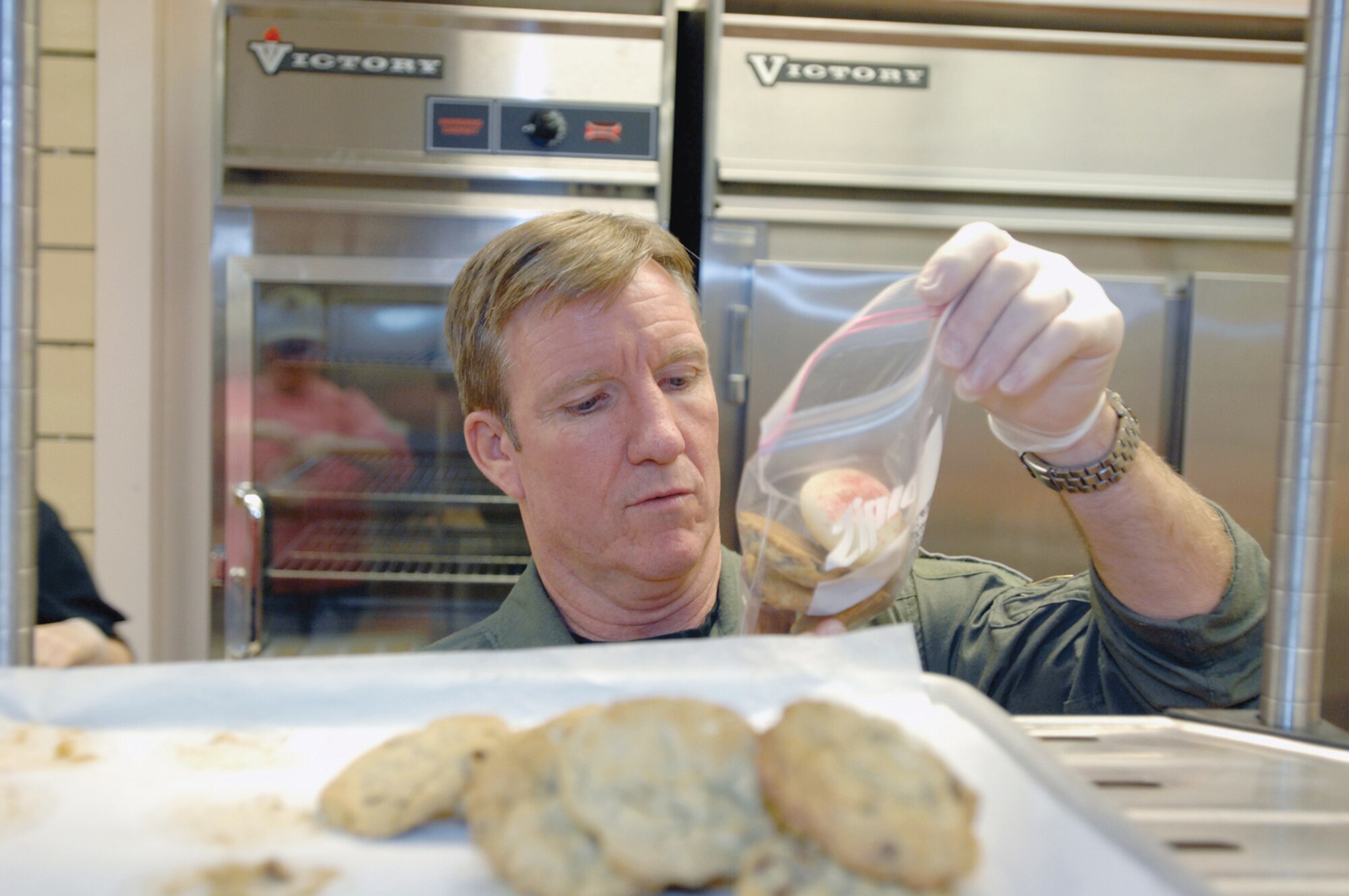 Brig. Gen. Hawk Carlisle, 3rd Wing commander, sorts through cookies and fills bags up to get them ready to hand out to Airmen during the holidays. Volunteers baked cookies as part of the annual cookie caper. The cookies were then delivered by Gen. Carlisle, Col. Scotty Lewis, 3rd Wing vice commander and Chief Master Sgt. Timothy Carroll, 3rd Wing command chief.
(U.S. Air Force photo by Tech. Sgt. Keith Brown)