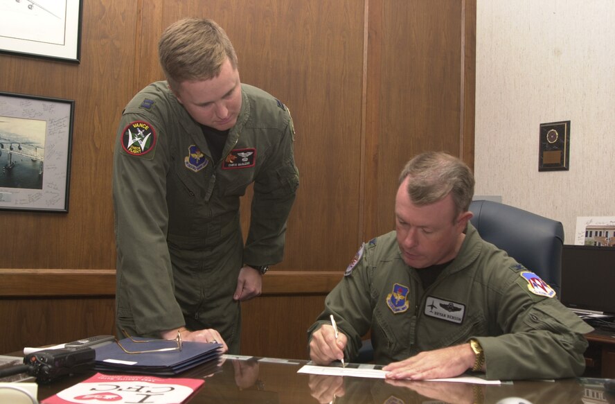 (Photo by Staff Sgt. Amanda Mills) Capt. Christopher McAlear, 33rd Flying Training Squadron and 71st Flying Training Wing Combined Federal Campaign project officer, waits while Col. Bryan Benson, 71st FTW commander, completes his contribution form. The Vance Air Force Base CFC begins Tuesday and runs until Nov. 18.