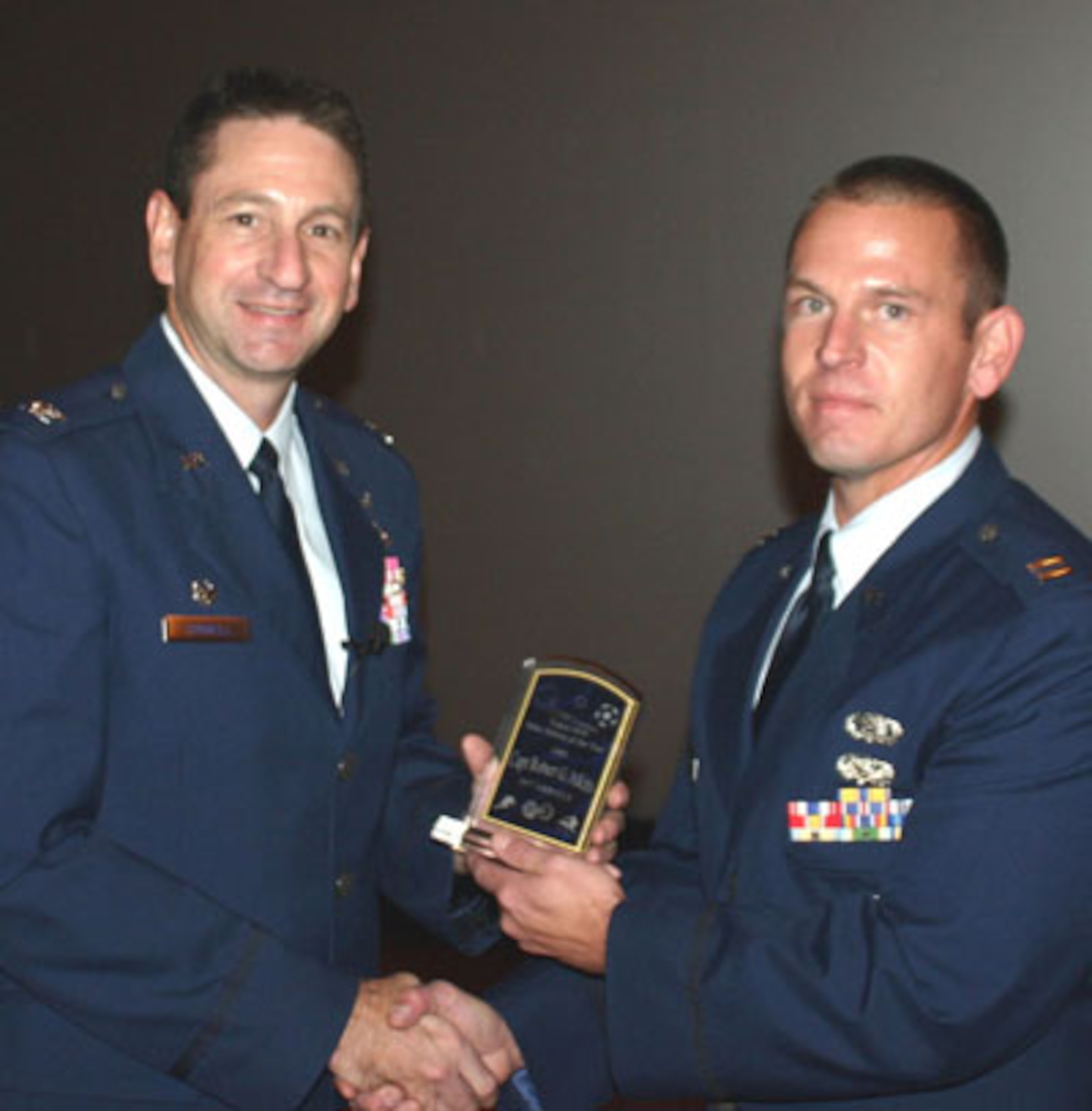 Col. Mark Correll, 72nd Air Base Wing commander, presents the Tinker Air Force Base Athlete of the Year trophy to Capt. Robert Atkins.
