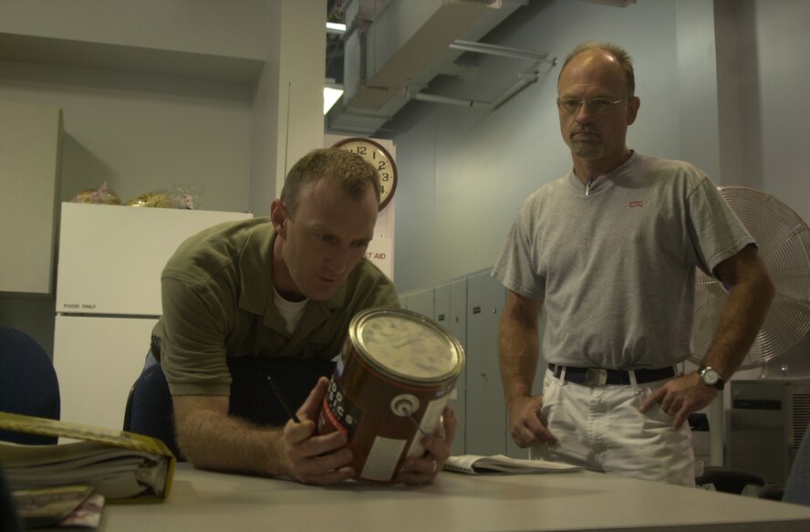 (Photo by Staff Sgt. Amanda Mills) Bill Steinhauser, ESOHCAMP inspector, ensures a can of paint is inventoried as Grant Klasing, Computer Sciences Corporation civil engineering, stands by during Vance’s external inspection.
