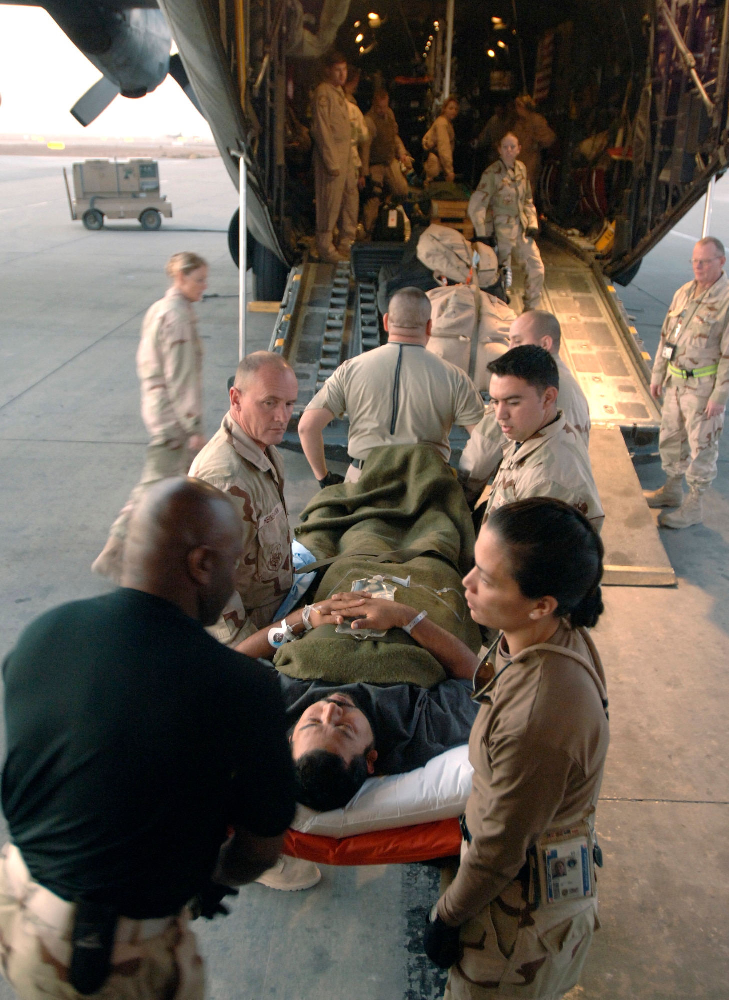 Medics carry a U.S. civilian contractor onto a C-130 Hercules Nov. 22 at the 332nd Contingency Aeromedical Staging Facility during a temporary stop at Balad Air Base in Iraq. (U.S. Air Force photo/Master Sgt. Scott Wagers) 