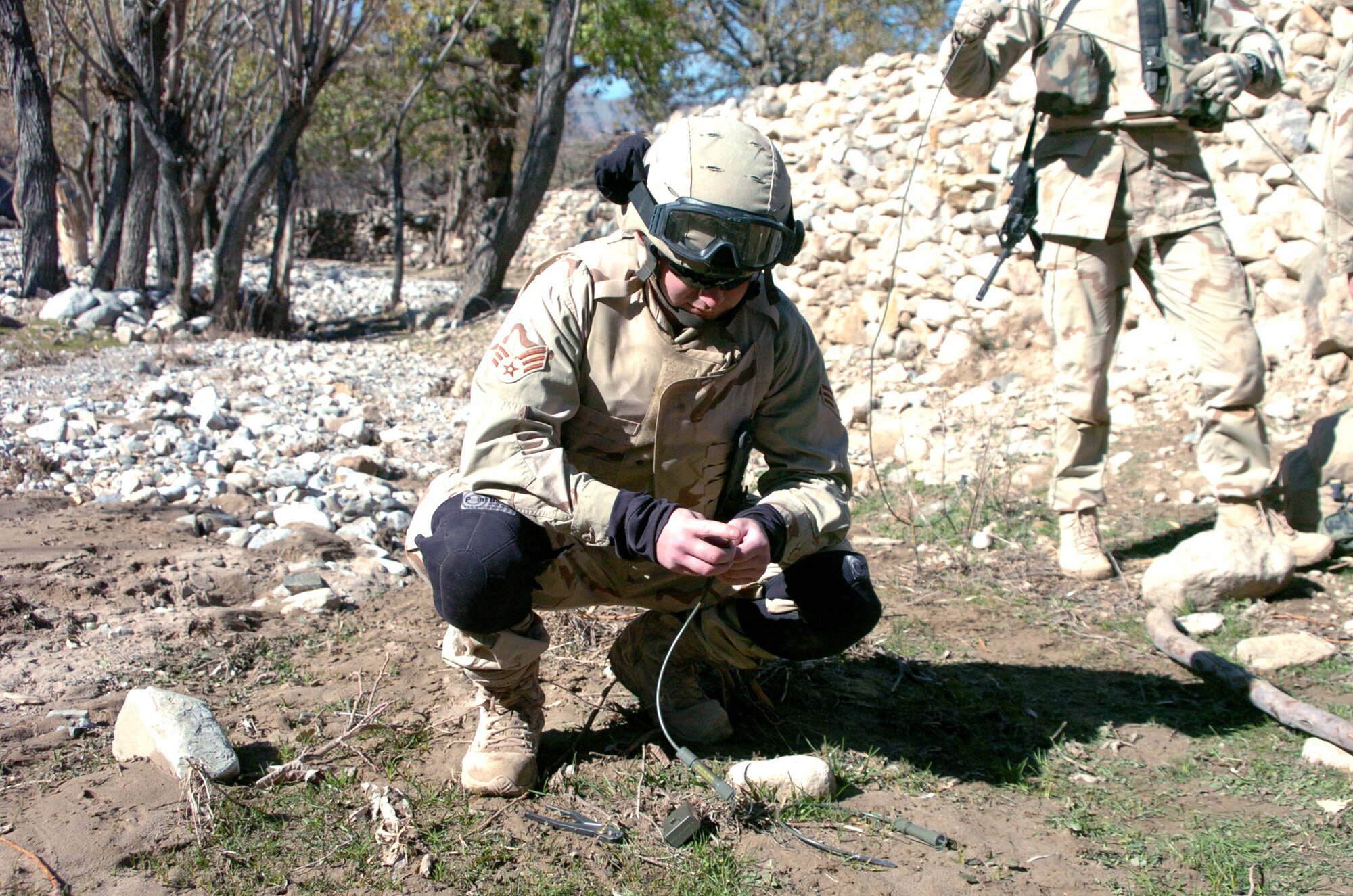 Senior Airman Aaron Cantu prepares detonation cord after finding an unexploded round in the mountain side during a search of suspected weapon caches Nov. 25 in Landikheyl, Afghanistan. Airman Cantu is assigned to the Explosive Ordnance Disposal/Operating Location A, and attached to the 63rd Ordnance Battalion. (U.S. Army photo/Cpl. Bertha A. Flores)