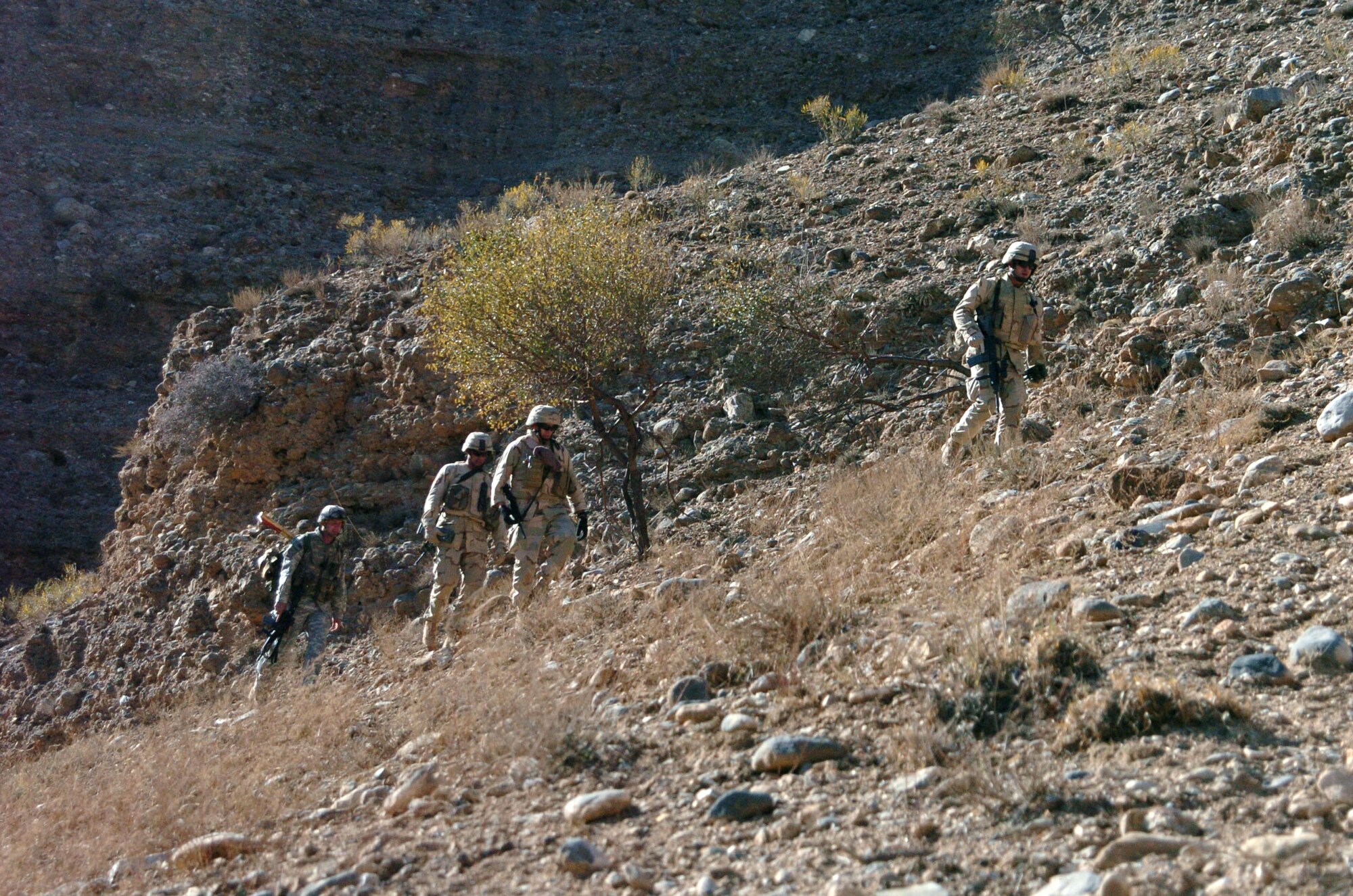 From right, Staff Sgt. Christian McKay, Master Sgt. Ken Niemerg, Maj. Shawn Murphy and Army Sgt. Michael Schobey watch their footing as they hike along a mountain ridge in search of suspected weapons caches Nov. 25 in Landikheyl, Afghanistan. Sergeants McKay and Niemberg and Major Murphy are assigned to the Explosive Ordnance Disposal/Operating Location A, and attached to 63rd Ordnance Battalion. Sergeant Schobey is from Task Force Gauntlet, 10th Mountain Division. (U.S. Army photo/Cpl. Bertha A. Flores) 
