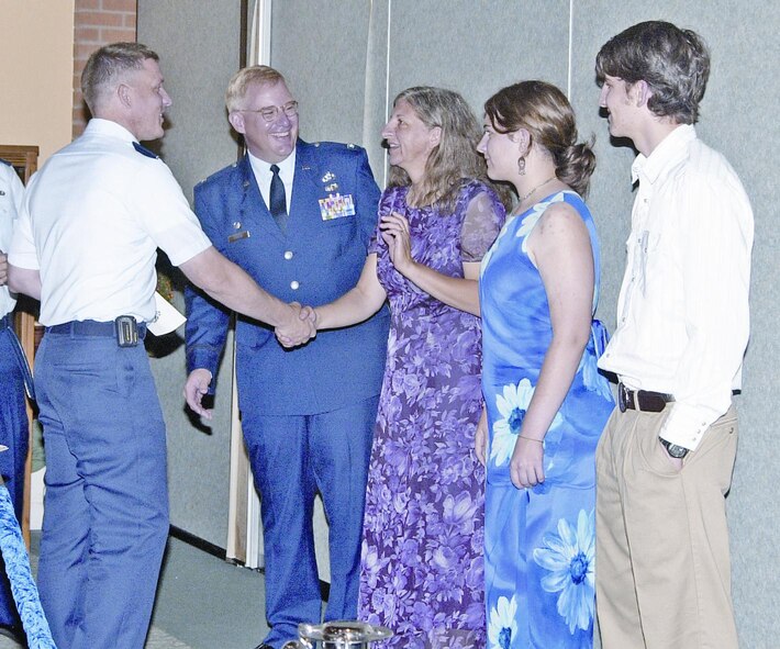 (Photo by Staff Sgt. Amanda Mills) Maj. Dennis Hunt, 71st Comptroller Squadron commander, welcomes Col. Christopher Thelen, new 71st Mission Support Group commander, and Colonel Thelen’s wife Carol, daughter Corey and son Matthew to Vance Air Force Base, during Colonel Thelen’s reception at the club.