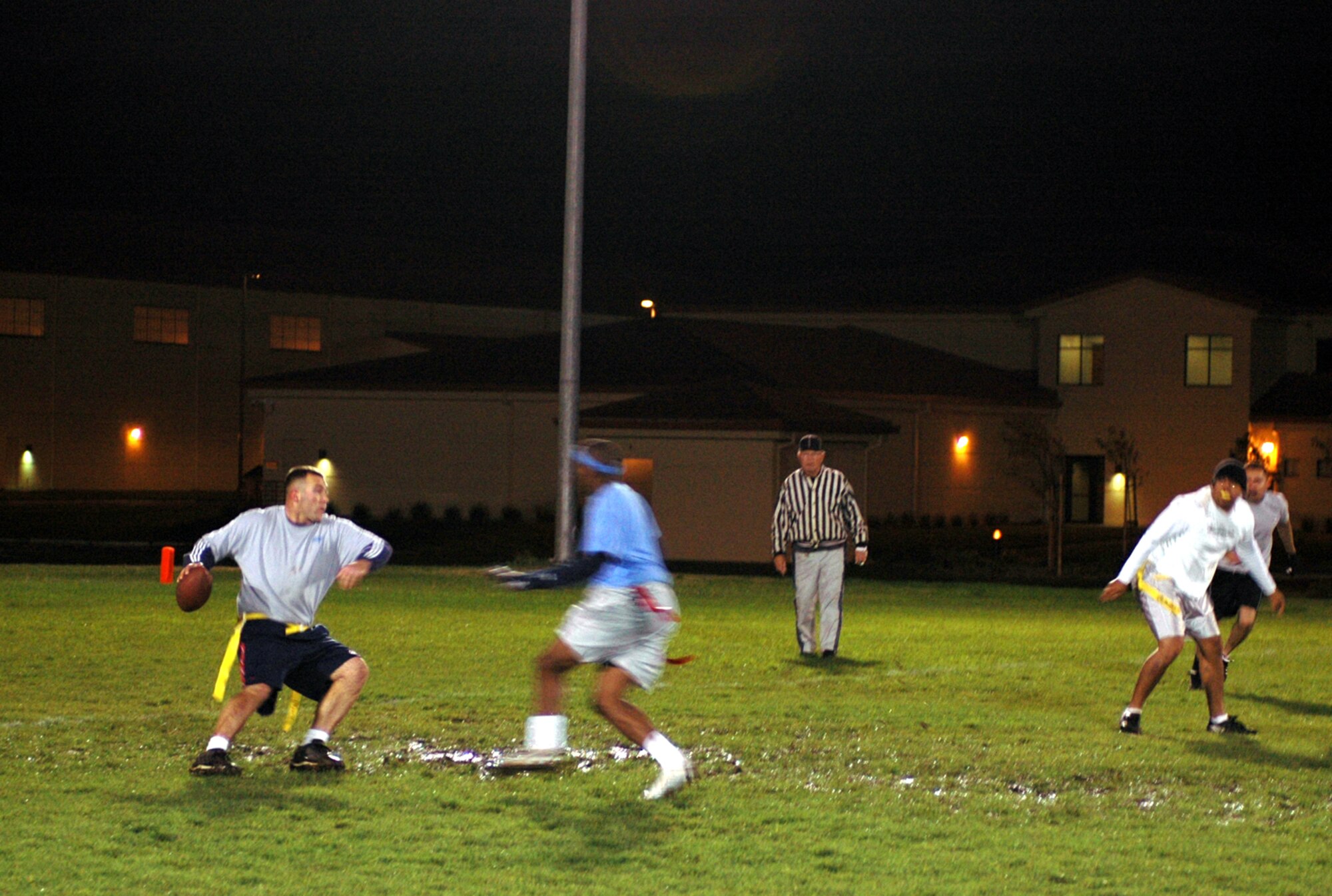 The 15th Air Mobility Operations Squadron quarterback, Jeff Panter [left] looks for an open teammate before Jerron Johnson, 60th Operations Support Squadron, completes a sack at Travis Air Force Base, Calif. (U.S. Air Force photo by Staff Sgt. Matthew McGovern)