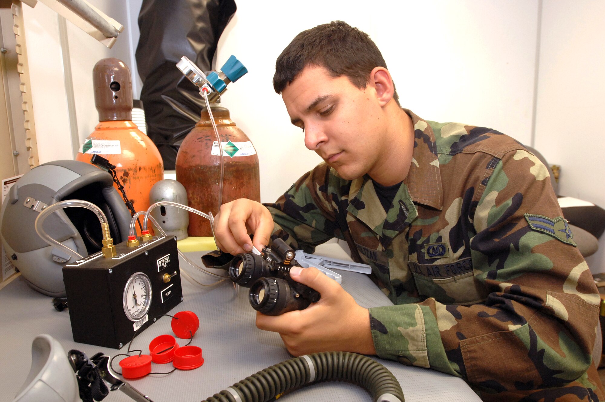 Airman 1st Class Zackary Koltzan, Aircrew Life Support technician, purges the ambient air with nitrogen in the monocular housing of night vision goggles. He is part of the Life Support flight under the 60th Operations Support Squadron. (U.S. Air Force photo/Nan Wylie)
