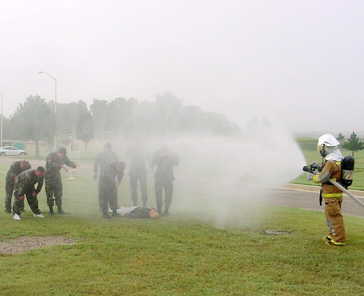 (Photo by Richard Shepard) People “exposed” to a skin irritant during Tuesday’s exercise are sprayed down by a fire department member. Team Vance’s Operational Readiness Inspection ends Tuesday.