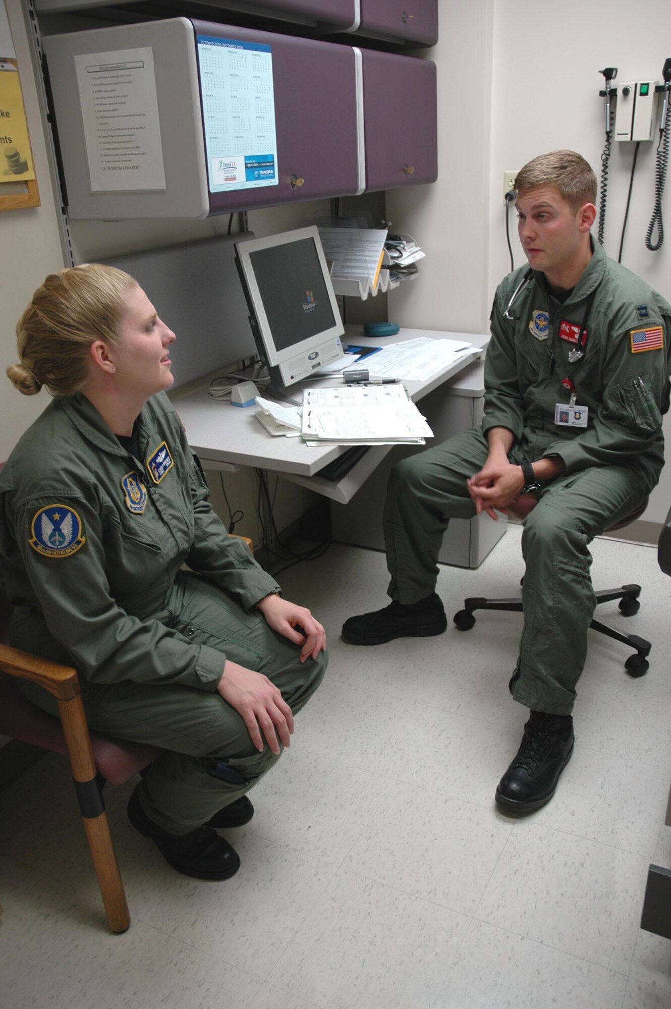 Tech. Sgt. Carla Horner, an 18th Air Refueling Squadron boom operator, discusses flight physical results with Capt.(Dr.) Joshua Hartman, a flight medicine doctor at the McConnell clinic. Sergeant Horner will deploy to Guam this month. (U.S. Air Force Photo/Senior Airman Amanda Currier.)