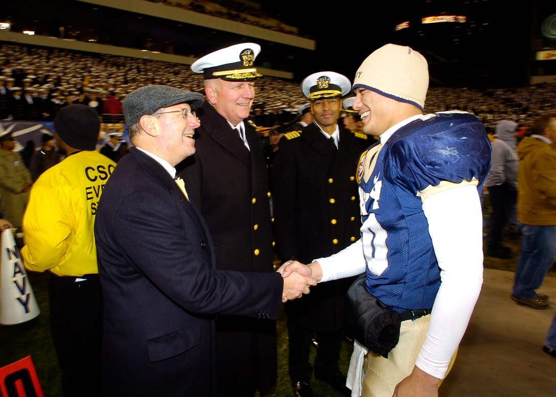 Secretary of the Navy Dr. Donald C. Winter congratulates Naval Academy Midshipmen quarterback Kaipo-Noa Kaheaku-Enhada (10), from Kapolei, Hawaii, after leading his team to a 26-14 win over the Black Knights of Army at Lincoln Financial Field in Philadelphia. Navy completed its winning season at 9-3, and has accepted an invitation to play in the Meineke Car Care Bowl, in Charlotte, N.C., scheduled for Dec. 30, 2006. 