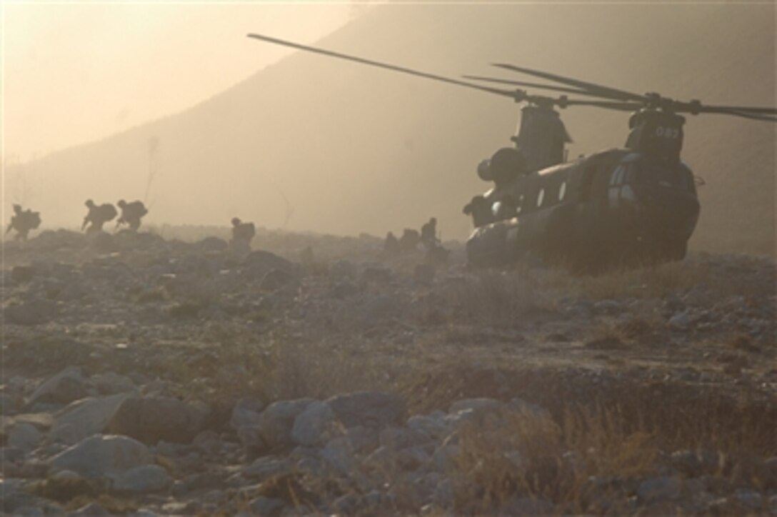 Soldiers from the 10th Mountain Division (Light Infantry) exit a CH-47 Chinook helicopter Nov. 25, 2006, to conduct a search for weapons caches in Landikheyl, Afghanistan.