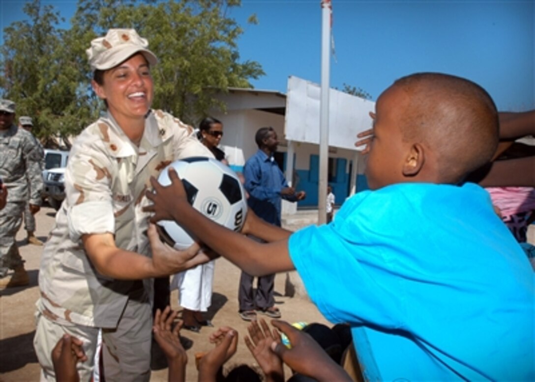 Navy Lt. Cmdr. Wendy Halsey, assigned to Combined Joint Task Force - Horn of Africa, hands out soccer balls to students in Balbala, Djibouti. 