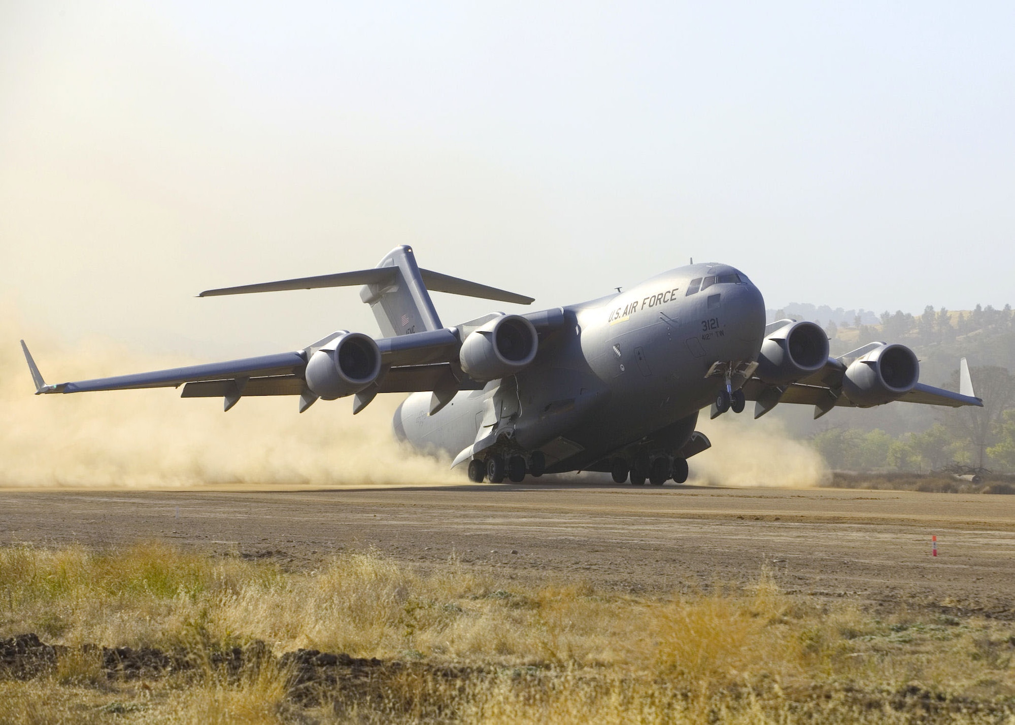 A C-17 Globemaster III takes off from Fort Hunter Liggett, Calif., Sept. 23, 2006, while performing take-off and landing testing on semi-prepared runways. The first of four test phases was conducted at Fort Hunter Liggett to validate the ability of the aircraft to bring a large force into a wet or dry dirt airfield without making runway condition corrections. (Photo by Bobbi Zapka)