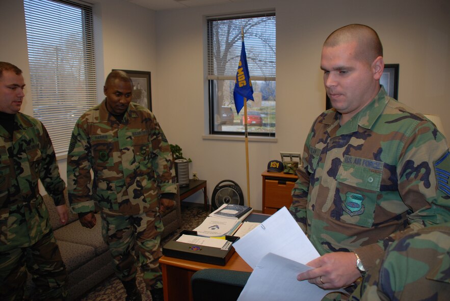 Master Sgt. Chris Morlan helps two Airmen of the 932nd Airlift Wing prepare for a reenlistment ceremony.  He attended the Human Resources Development Council meeting in Colorado, and was also named Air Force Reserve Command Career Assistance Advisor of the Year for 2005.  Photo/Tech Sgt. Dan Oliver, AFRC