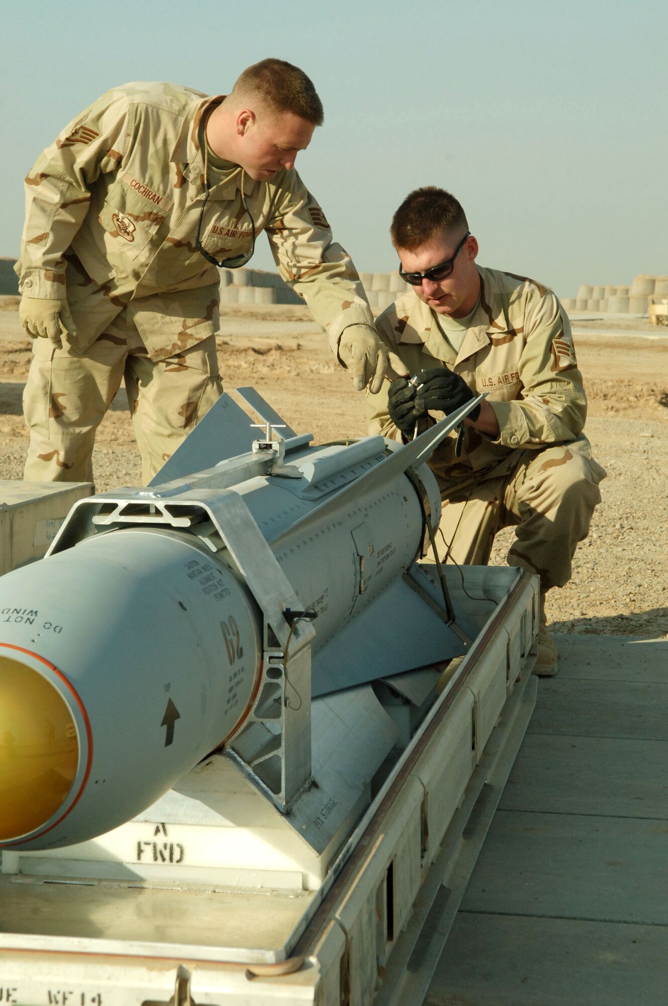 Staff Sergeant Chris Cochran and Senior Airman Jason Williamson inspect the triggering device on a missile Nov. 29 at Balad Air Base, Iraq. Both are assigned to the 332nd Expeditionary Maintenance Squadron Ammunition Flight. Sergeant Cochran is deployed from Cannon Air Force Base, N.M., and Airman Williamson is deployed from Sioux Falls, S.D. (U.S. Air Force photo/Airman 1st Class Chad M. Kellum) 