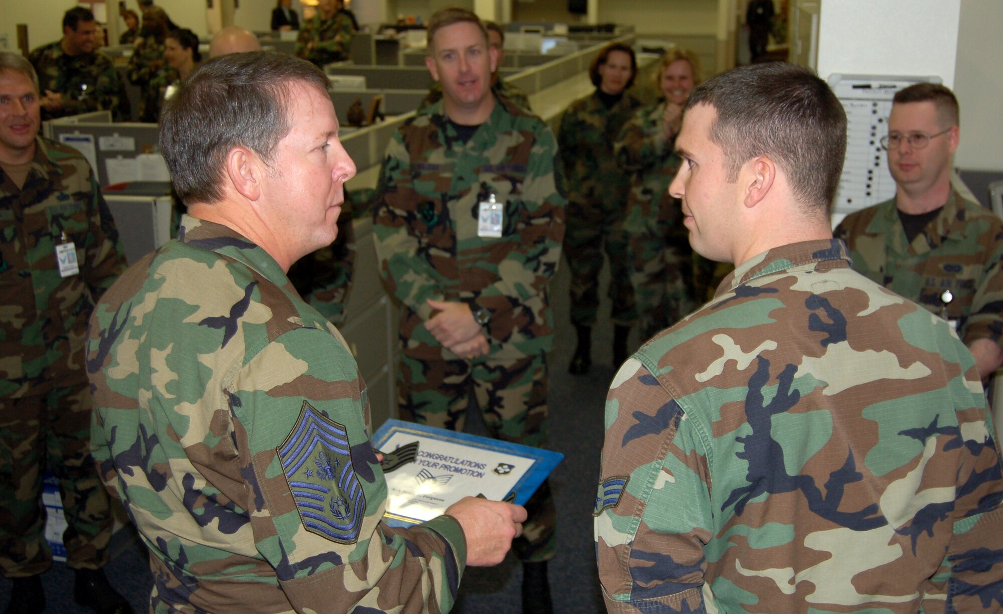 Chief Master Sgt. of the Air Force Rodney J. McKinley congratulates Senior Airman Brian Ferguson on his promotion to staff sergeant during his visit to the Air Force News Agency in San Antonio, Texas, on Dec. 5. Airman Ferguson was deployed during the testing cycle and tested out of cycle earlier this month.  The Air Force News Agency photojournalist received his promotion under the supplemental selection board. (U.S. Air Force photo/Tech. Sgt. Larry Simmons)