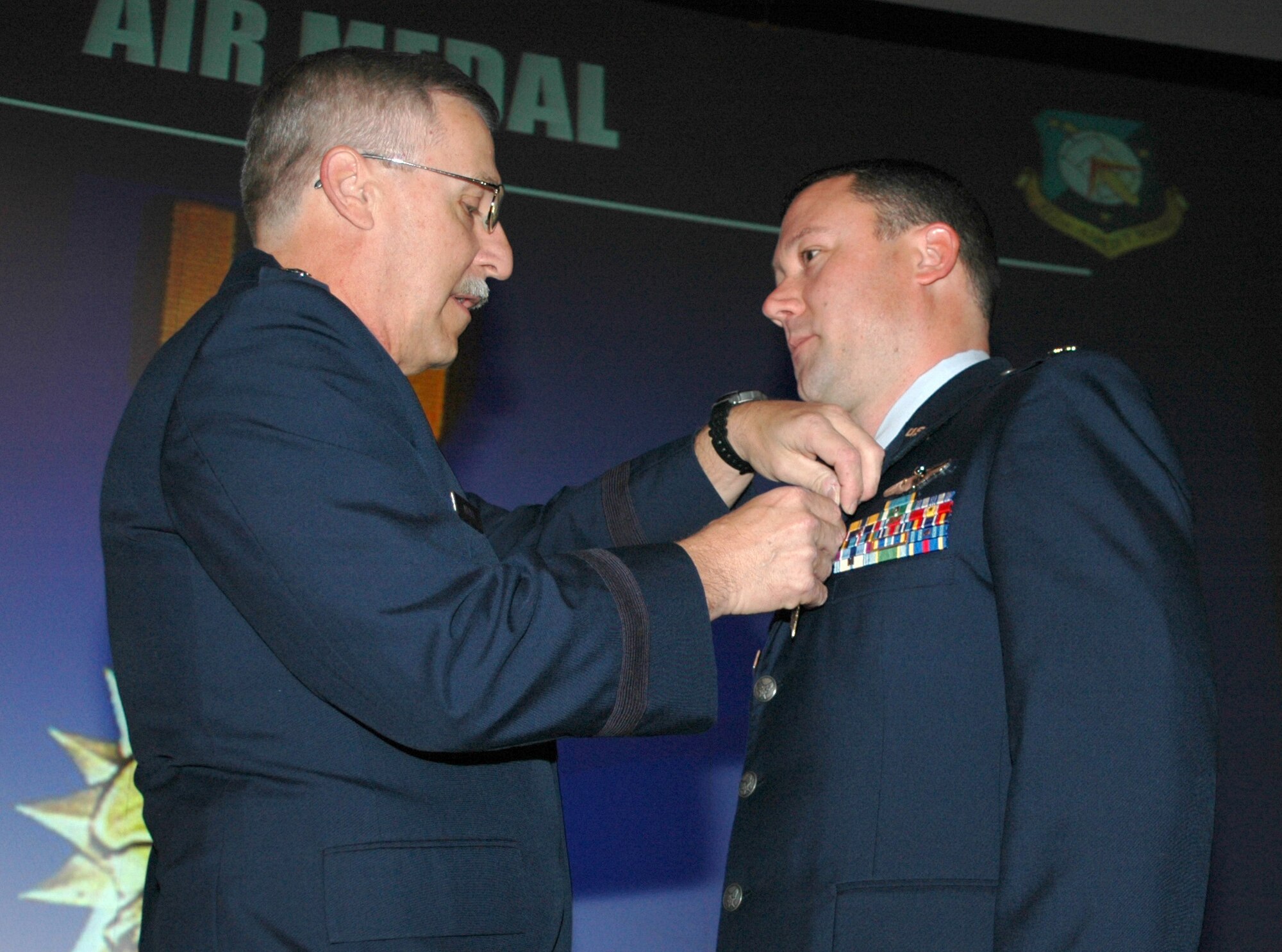 Maj. Gen. Martin M. Mazick, 22nd Air Force commander, presents an air medal to Maj. Kyle Pangle, 326th Airlift Squadron pilot, during the 512th Airlift Wing commander's call Dec. 3. General Mazick visited the 512th AW Dec. 1-3 as part of a multi-wing tour of 22nd AF units. (U.S. Air Force photo/Senior Airman Red Scofield)