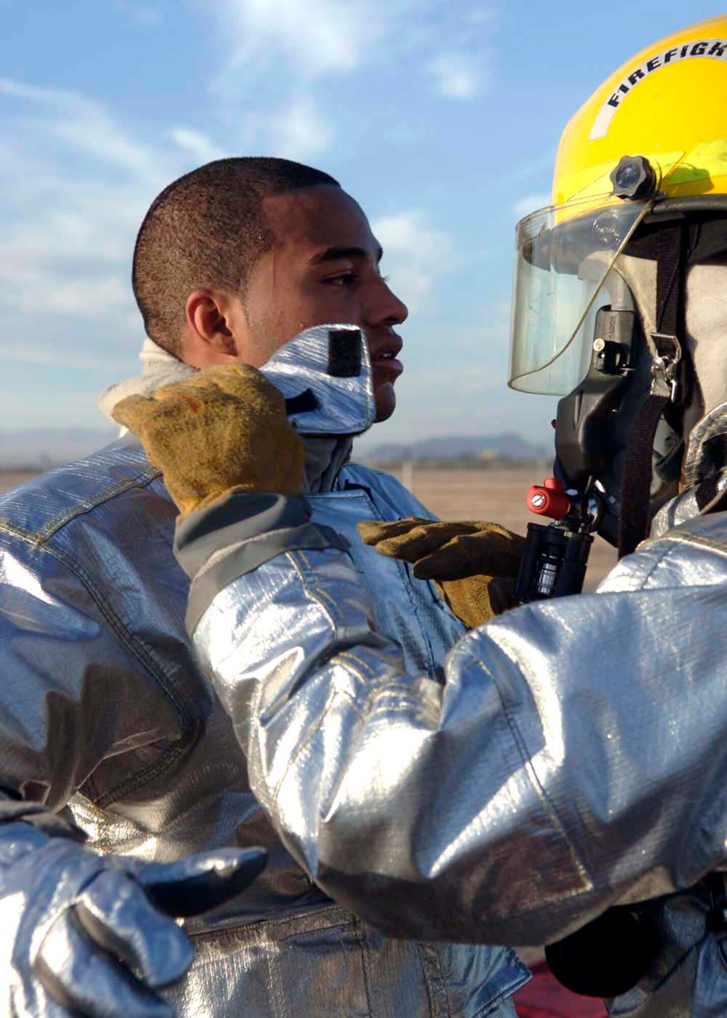 A Davis-Monthan Air Force Base firefighter helps out a fellow wingman as part of processing through the decontamination stations Dec. 4 at Davis-Monthan AFB, Ariz. Exercise Vigilant Shield 07 is a joint Department of Defense and federal nuclear weapon accident exercise. The exercise scenario involved a C-17 Globemaster III carrying four nuclear weapons to be diverted to Davis-Monthan AFB due to simulated engine failure that caused an aircraft accident. Davis-Monthan firefighters, the Tucson Fire Department, Tucson Police Department, and many different agencies ranging form local to national levels responded to the simulated scene. (U.S. Air Force photo/Senior Airman Christina D. Ponte)