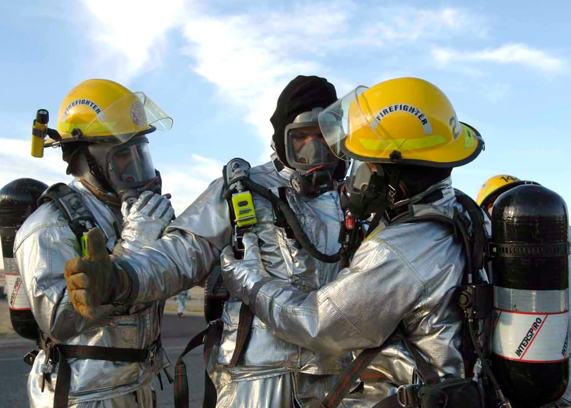 Davis-Monthan Air Force Base firefighters help one another in the decontamination process Dec. 4 at Davis-Monthan AFB, Ariz. Exercise Vigilant Shield 07 is a joint Department of Defense and federal nuclear weapon accident exercise. The exercise scenario involved a C-17 Globemaster III carrying four nuclear weapons to be diverted to Davis-Monthan AFB due to simulated engine failure that caused an aircraft accident. Davis-Monthan firefighters, the Tucson Fire Department, Tucson Police Department, and many different agencies ranging form local to national levels responded to the simulated scene. (U.S. Air Force photo/Senior Airman Christina D. Ponte)