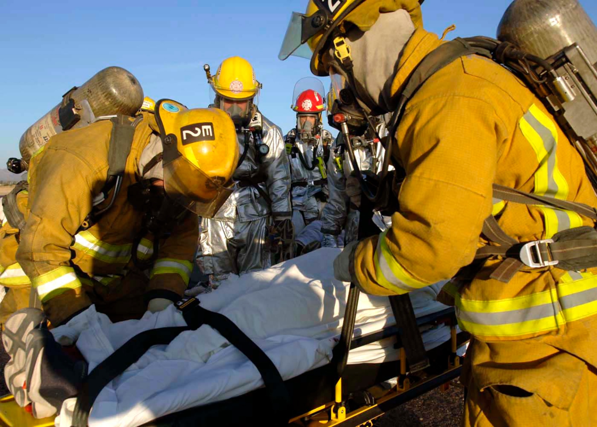 Firefighters from Davis-Monthan Air Force Base and the Tucson Fire Department provide temporary treatment to survivors of a simulated aircraft accident prior to being transported to a local hospital Dec. 4 at Davis-Monthan AFB, Ariz. Exercise Vigilant Shield 07 is a joint Department of Defense and federal nuclear weapon accident exercise. The exercise scenario involved a C-17 Globemaster III carrying four nuclear weapons to be diverted to Davis-Monthan AFB due to simulated engine failure that caused an aircraft accident. Davis-Monthan firefighters, the Tucson Fire Department, Tucson Police Department, and many different agencies ranging form local to national levels responded to the simulated scene. (U.S. Air Force photo/Senior Airman Christina D. Ponte) 