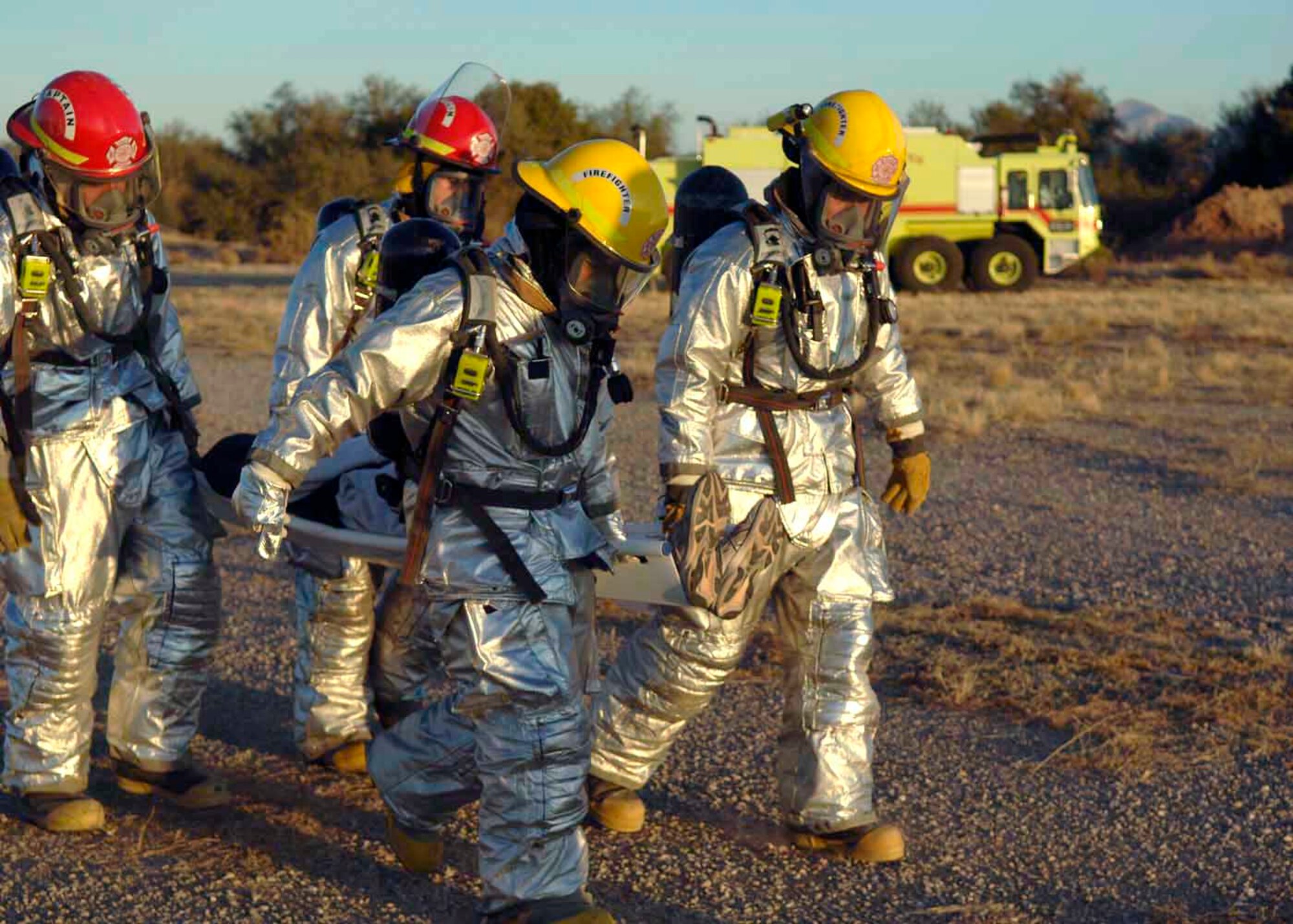 Davis-Monthan Air Force Base firefighters carry a survivor from a simulated aircraft accident to an ambulance for transportation to a local hospital Dec. 4 at Davis-Monthan AFB, Ariz. Exercise Vigilant Shield 07 is a joint Department of Defense and federal nuclear weapon accident exercise. The exercise scenario involved a C-17 Globemaster III carrying four nuclear weapons to be diverted to Davis-Monthan AFB due to simulated engine failure that caused an aircraft accident. Davis-Monthan firefighters, the Tucson Fire Department, Tucson Police Department, and many different agencies ranging form local to national levels responded to the simulated scene. (U.S. Air Force photo/Senior Airman Christina D. Ponte)