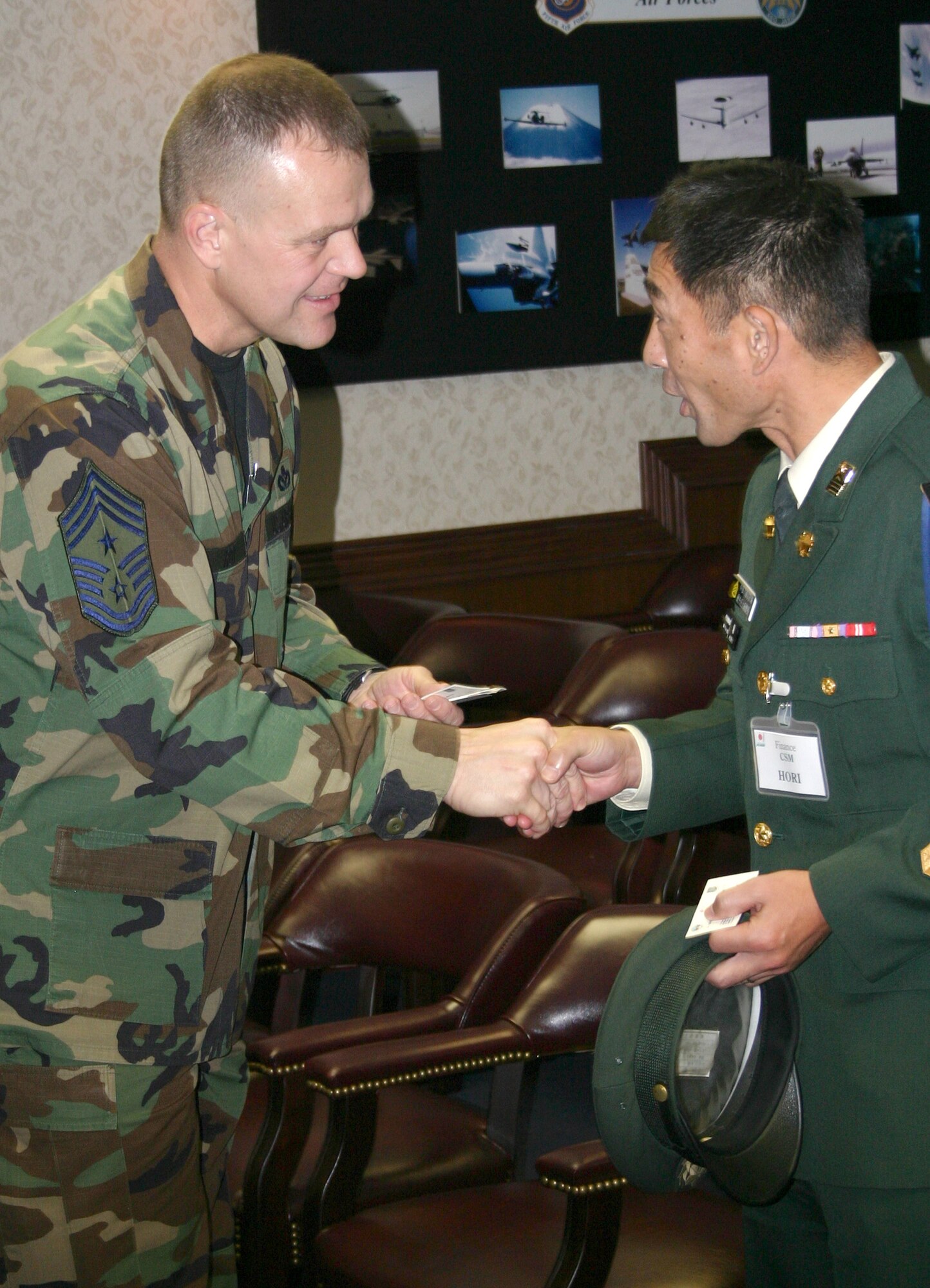 Chief Master Sgt. James Roy speaks to Japanese Ground Self Defense Force Warrant Officer Katsuhiko Hori Nov. 29 at Yokota Air Base, Japan, during a senior enlisted leader exchange conference. Fifth Air Force and U.S. Forces Japan served as host for a 17-member delegation of Japanese senior enlisted leaders interested in learning best practices and improving enlisted force development in the Japanese army. Chief Roy is the command chief for 5th AF and U.S. Forces Japan and Warrant Officer Hori is the command sergeant major of the Japanese Middle Army Finance Command. (U.S. Marine photo/Master Sgt. Terence R. Peck)