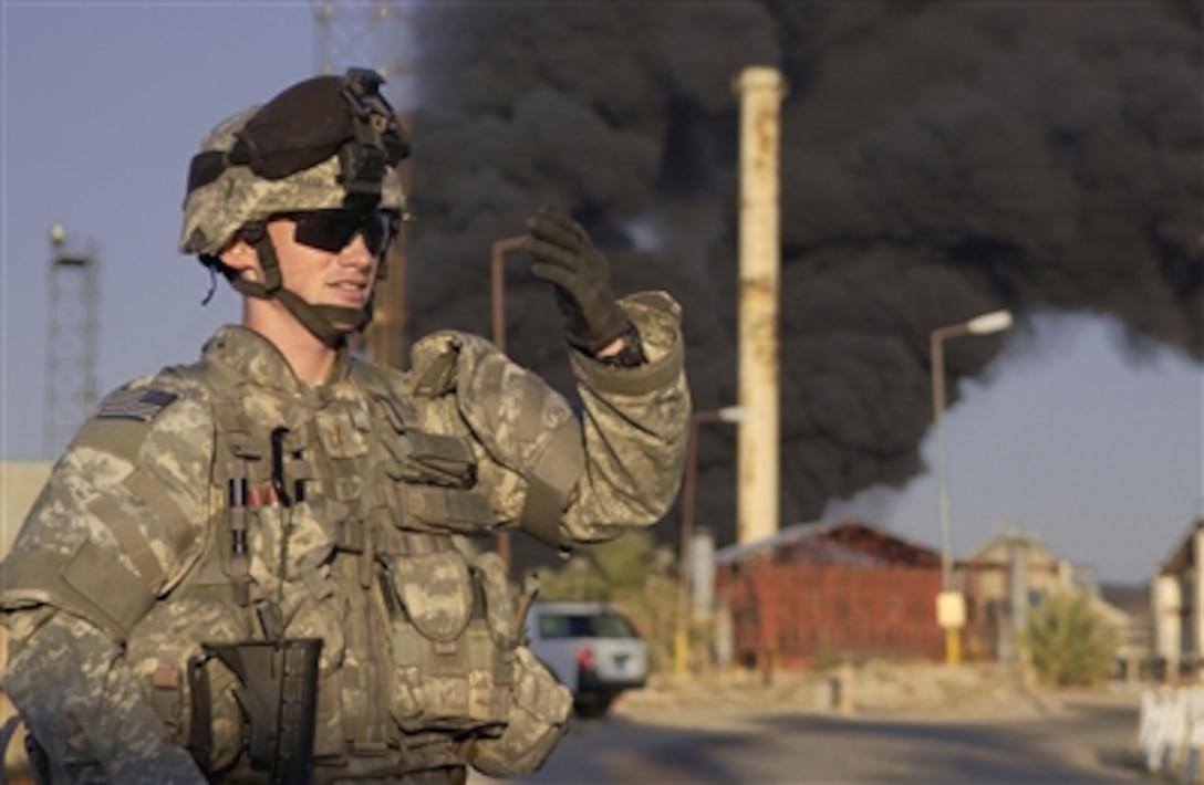 U.S. Army 2nd Lt. Matthew Lloyd directs emergency vehicles following a rocket attack on a pipeline feeding a 10,000 liter holding tank at the Northern Oil Company in Kirkuk, Iraq, on Nov. 27, 2006.  