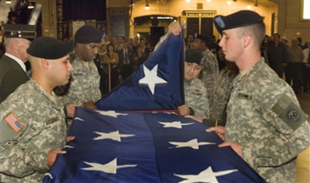 From left, U.S. Army Sgt. Fabian Maldonado, Sgt. Casey Reefer, Sgt. 1st Class Norberto Carrasquillo and Pfc. Robert Tolas, from the 1st Battalion, 69th Infantry Regiment, New York Army National Guard, fold a 20' X 30' flag in Grand Central Terminal in New York City, N.Y., on Nov. 30, 2006.  The flag, which has been hanging in the terminal since shortly after Sept. 11, 2001, will be presented to soldiers from the 69th Infantry Regiment as a gesture for their sacrifice and service to their country at home and overseas.  