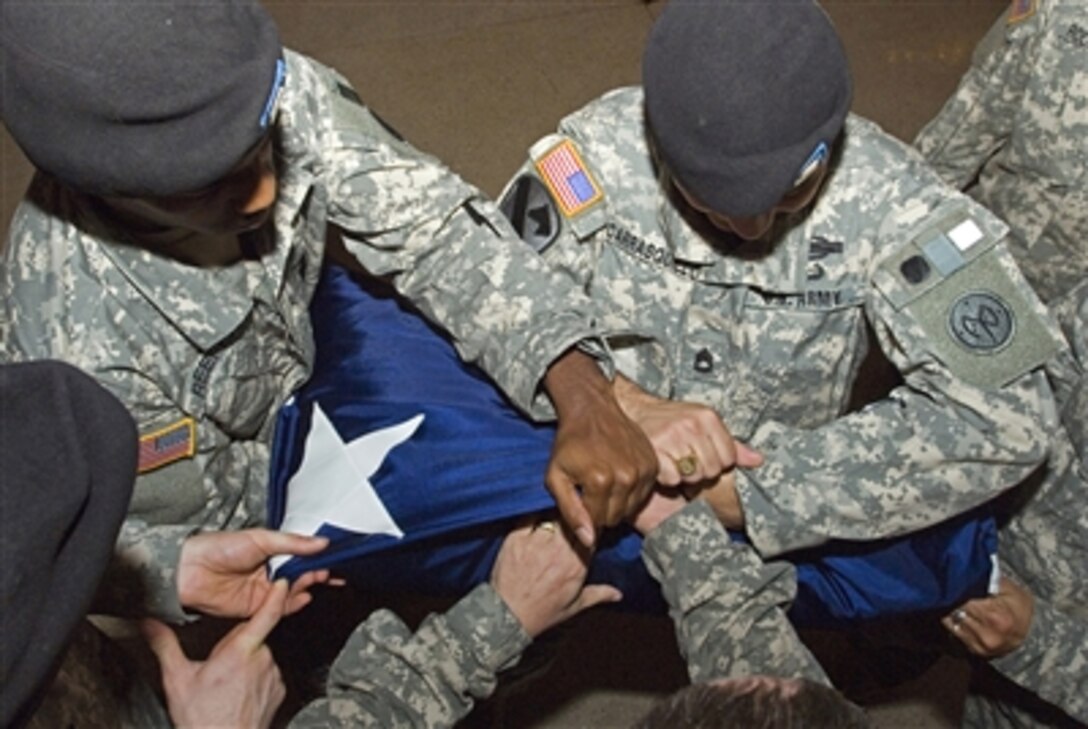 U.S. Army Sgt. Casey Reefer, left, Sgt. 1st Class Norberto Carrasquillo, both with the New York Army National Guard, practice folding a flag in Grand Central Terminal in New York City Nov. 29, 2006. The flag has been hanging in the terminal since shortly after Sept. 11, 2001.