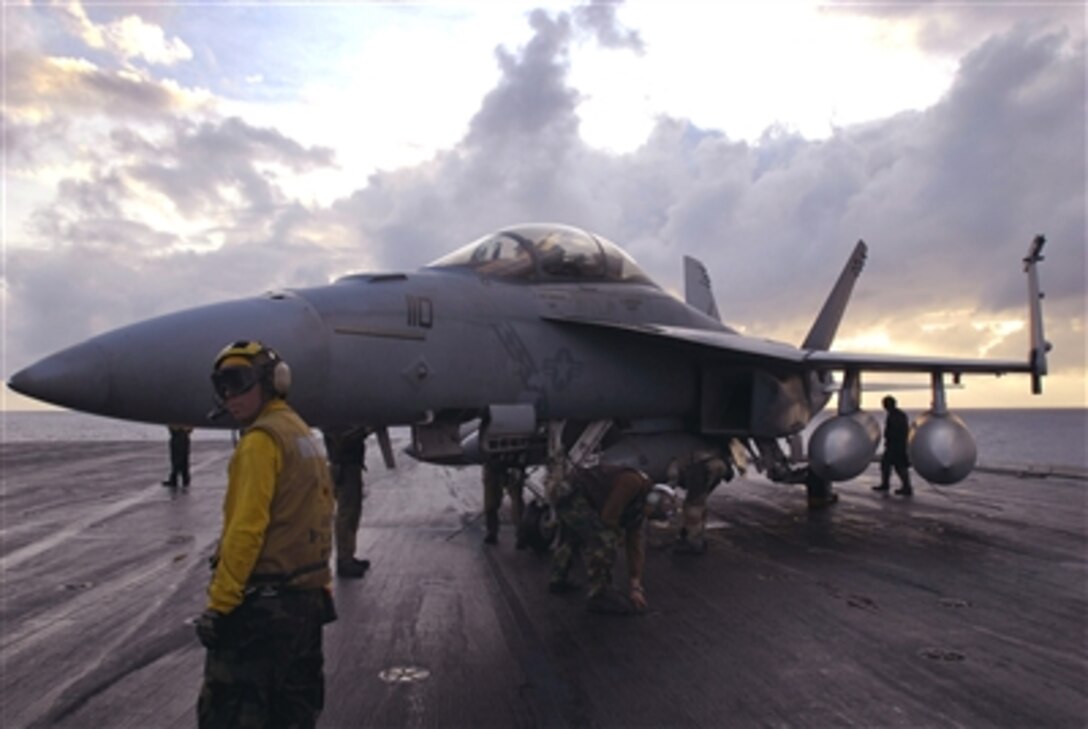 U.S. Navy sailors aboard USS Kitty Hawk chain down an F/A-18F Super Hornet aircraft after a flight Nov. 29, 2006. Kitty Hawk operates out of Fleet Activities Yokosuka, Japan, and is deployed in the Philippine Sea on a regularly scheduled deployment.