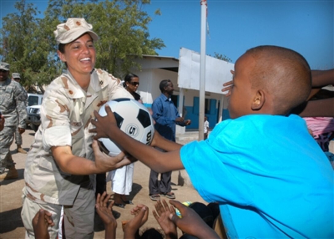 Navy Lt. Cmdr. Wendy Halsey hands out soccer balls to students from a school in Balbala, Djibouti, on Nov. 20, 2006.  Halsey, and other members of Combined Joint Task Force-Horn of Africa, collected more than 300 soccer balls from churches, schools and organizations around the United States for donation to schools and orphanages throughout the Horn of Africa.  