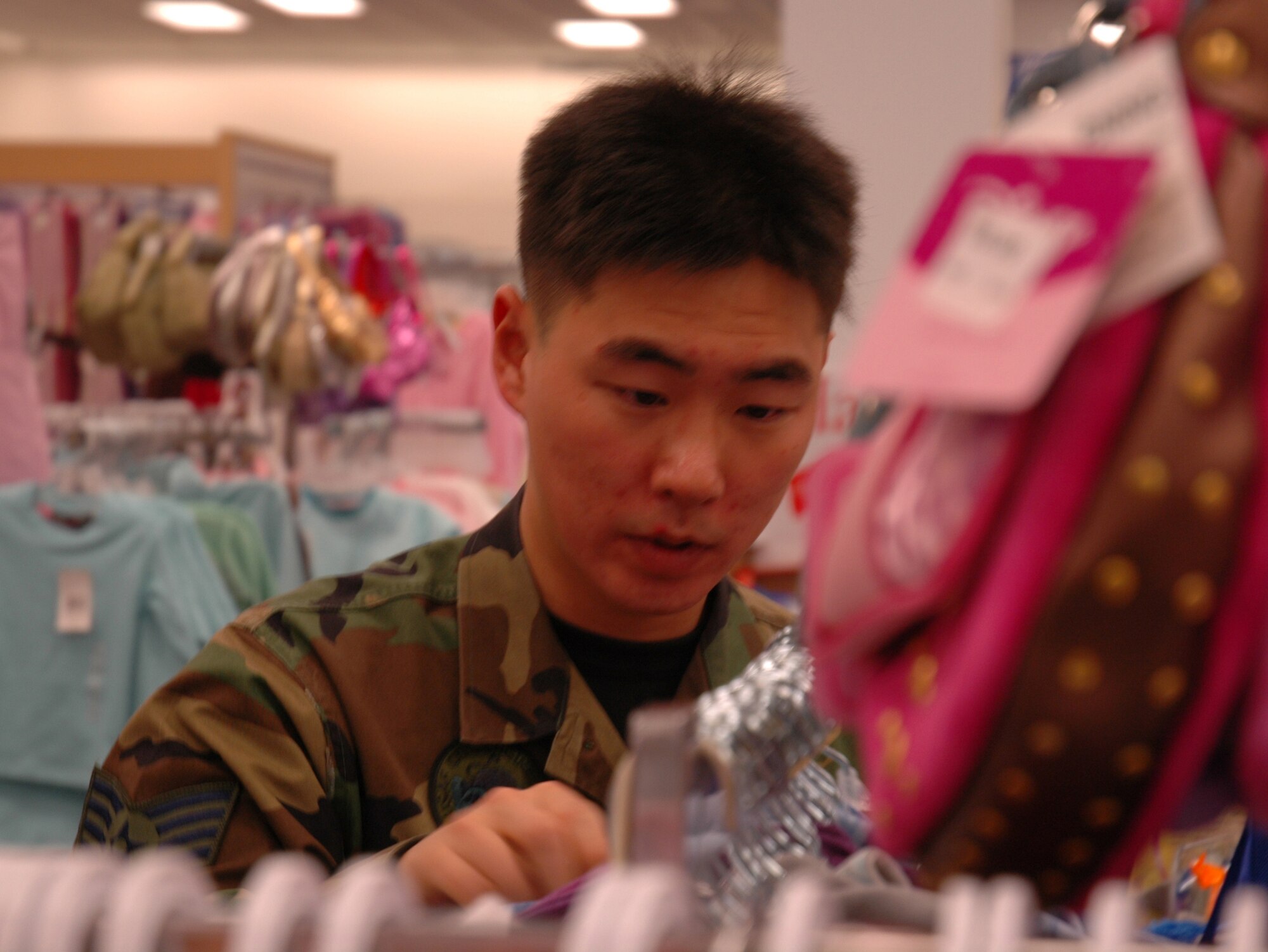 BUCKLEY AIR FORCE BASE, Colo. -- Staff Sgt. Hyun Yang, 460th Civil Engineer Squadron, shops for clothes as part of a shopping spree for the Angel Tree at the Buckley Exchange Dec. 6. Team Buckley first sergeants and other volunteers spent approximately $4,600 donated by the Homefront Heroes Denver chapter, a non-profit military support group. The Angel Tree project provides family members of all services', E-5's and below, gifts for the holidays. (U.S. Air Force photo by Staff Sgt. Sanjay Allen)
