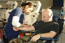 MINOT AIR FORCE BASE, N.D. --Tech. Sgt. John Gibson, 5th Maintenance Squadron, is being prepped for a blood donation by Adrianna Bueno, American Red Cross, during a blood drive at the McAdoo Sports and Fitness Center Wednesday. Sergeant Gibson is a regular blood donor. (U.S. Air Force photo by Airman 1st Class Christopher Boitz) 