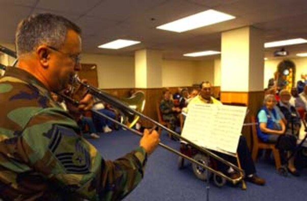 WASHINGTON, D.C. -- Senior Master Sgt. Ray Price, 459th Maintenance Squadron propulsion superintendent, plays slide trombone for Armed Forces Retirement Center residents Nov. 16. Sergeant Price played each service branch's anthem for the residents. (U.S. Air Force photo by Staff Sgt. Amaani Lyle)