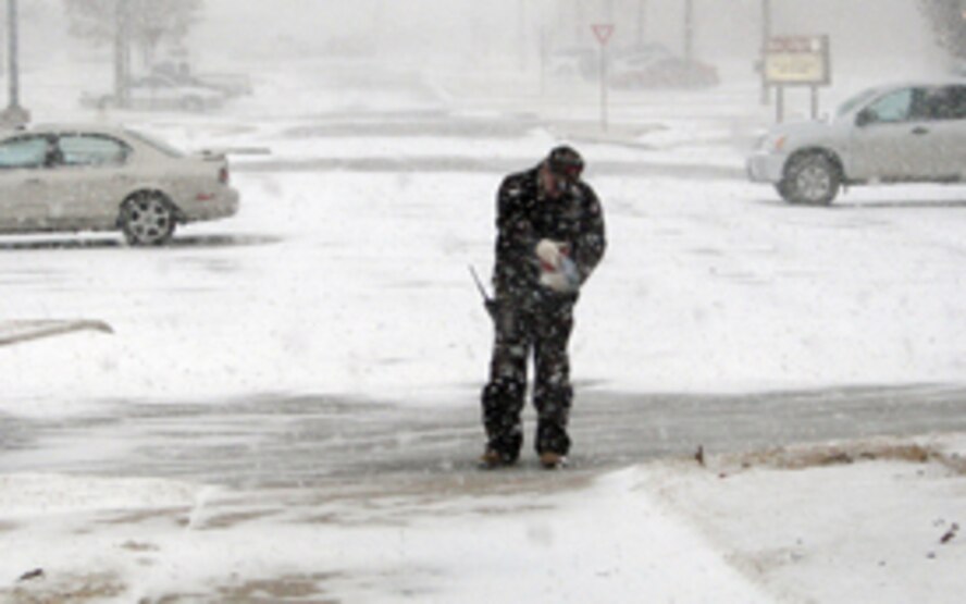(Photos by Frank McIntyre) Larry Freden, Computer Sciences Corporation, spreads ice melt to get an early start combatting the snow storm that closed the base Thursday.