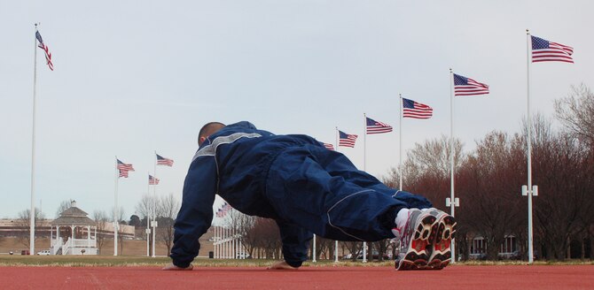 An Airman works out on the new exercise pad located at the south corner of the parade ground. The new pad, similar to the running surface in the Offutt Field House, is softer, drier and more forgiving than the concrete or grass that Team Offutt members had to use before it was built late this summer. (Air Force photo by 1st Lt. John Severns)