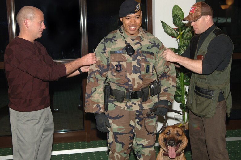 Col Kurt Lohide, 435th Air Base Wing Commander, left and Maj Ron Gray, 435th Security Forces Squadron Commander promoted Staff Sgt. Rodney Cochran to technical sergeant. Cochran, who got picked up in the supplemental board, arrived with his military working dog Boyke, to do a routine sweep of the building and unaware he was to be promoted.  

