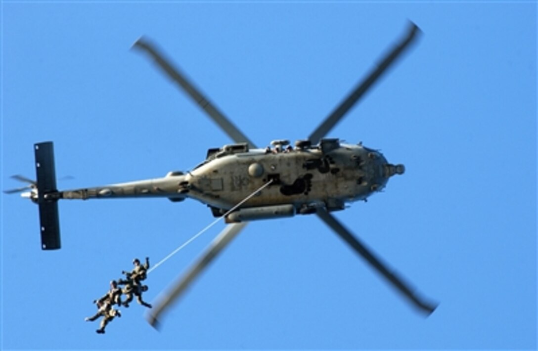 A Navy crew conducts a helicopter rope suspension techniques exercise from a SH-60F Seahawk assigned to Helicopter Anti-Submarine Squadron Six over the Pacific Ocean. 