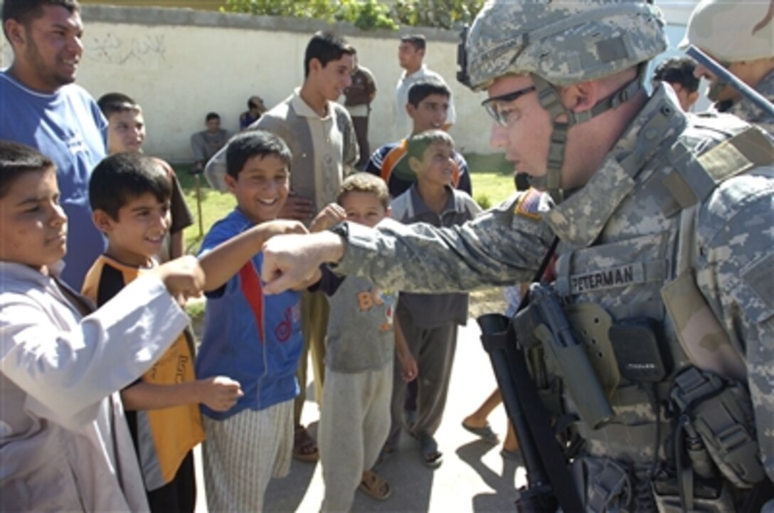Army Capt. Tim Peterman, commander, Company C, 1st Battalion, 505th Parachute Infantry Regiment, 82nd Airborne Division, interacts with Iraqi children during a patrol in Bayji.