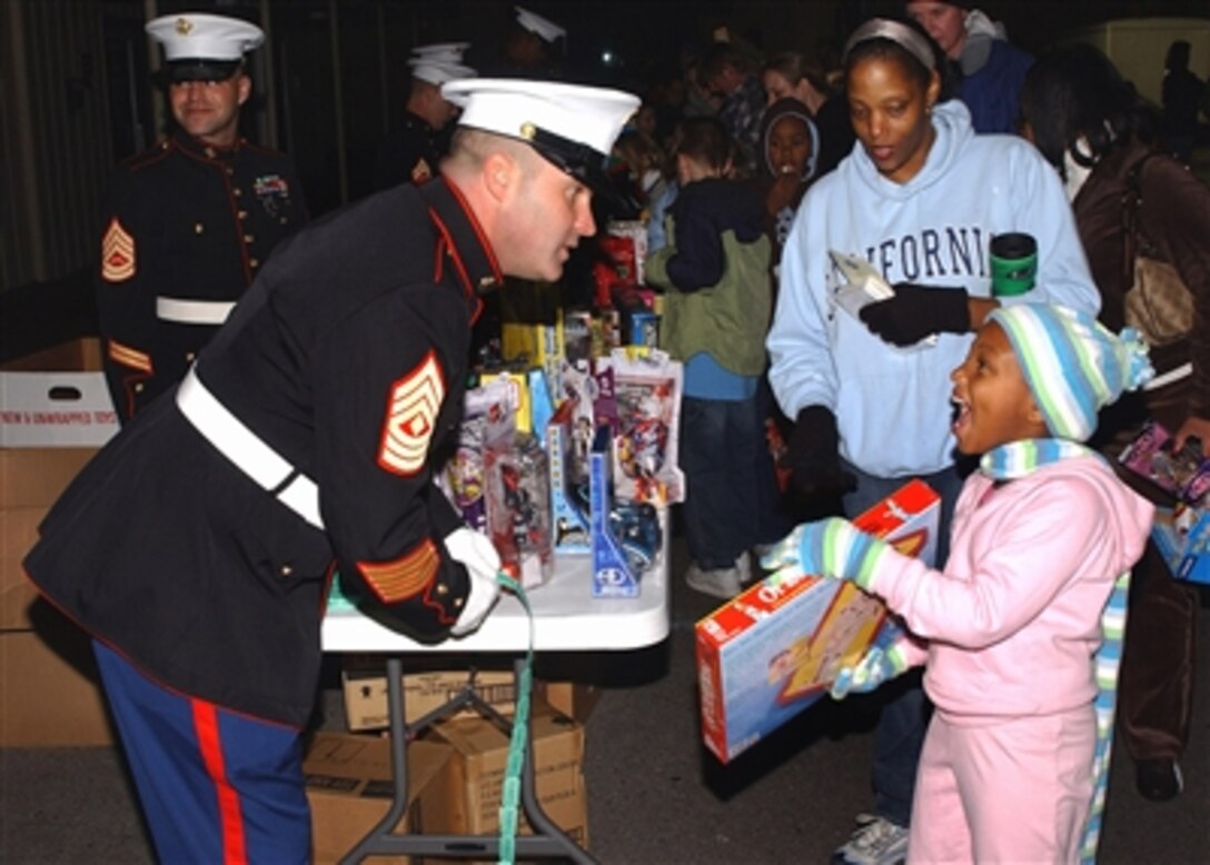 U.S. Marine Corps 1st Sgt. John Catalinie gives out toys to a child as part of the Marine Corps Toys for Tots Program at Naval Air Station Joint Reserve Base in New Orleans, Dec. 2, 2006.
