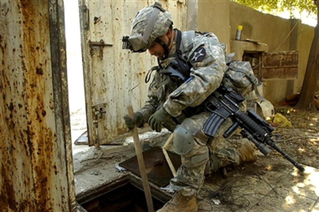 U.S. Army Staff Sgt. Juan Hernandez, Company A, 2nd Battalion, 12th Infantry Regiment attached to the 1st Cavalry Division’s 2nd Brigade Combat Team, searches a hole for illegal weapons during a cordon and search mission in Baghdad’s al-Doura neighborhood, Dec. 2, 2006.
