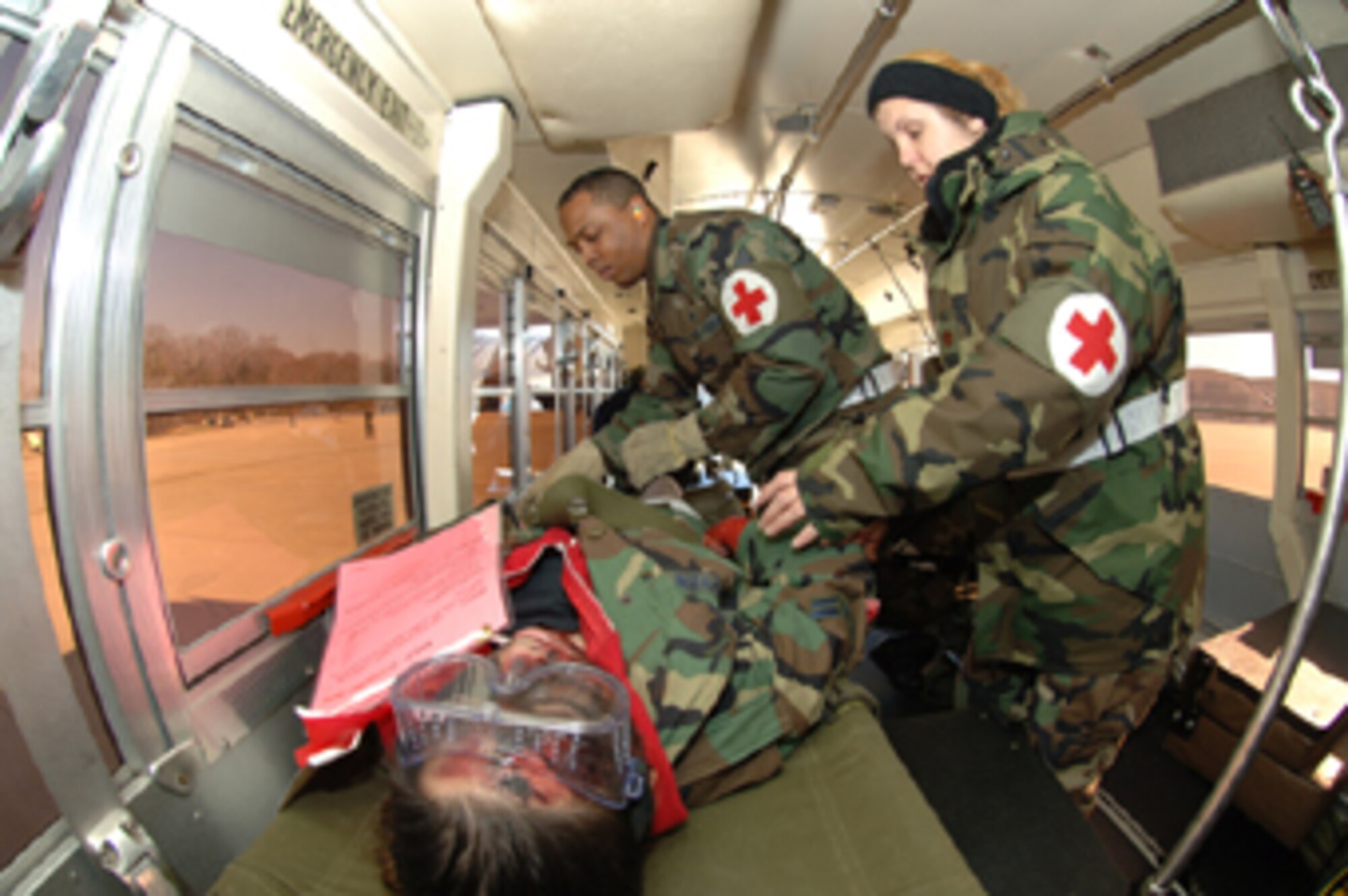 ANDREWS AIR FORCE BASE, Md. -- Senior Airman Duston Ashton, 459th Aeromedical Staging Squadron medical technician and Maj. Marie Sasse, 459th Aeromedical Staging Squadron flight nurse tend to a simulated burn victim during a mass casualty response as part of Exercise Capital Shield Dec. 7.  (U.S. Air Force photo/Tech. Sgt. Christopher Matthews)