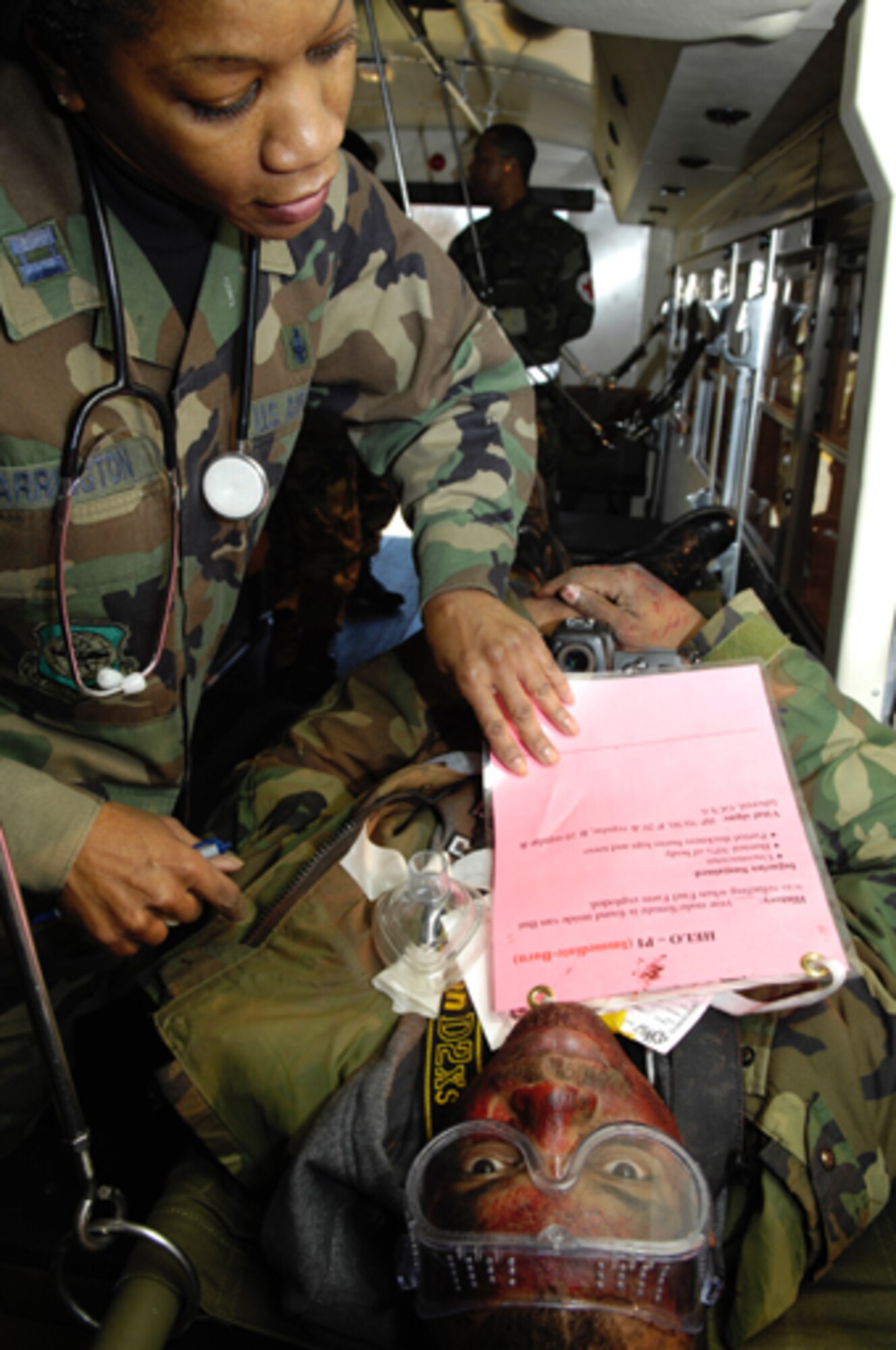 ANDREWS AIR FORCE BASE, Md. -- Capt. Sheila Arrington, 459th Aeromedical Staging Squadron flight nurse, checks the medical chart for a simulated burn victim during Exercise Capital Shield Dec. 7. The patient, Tech. Sgt. Cohen Young, is an embedded Air Force News Agency photojournalist. (U.S. Air Force photo/Airman 1st Class Rusti Caraker)
