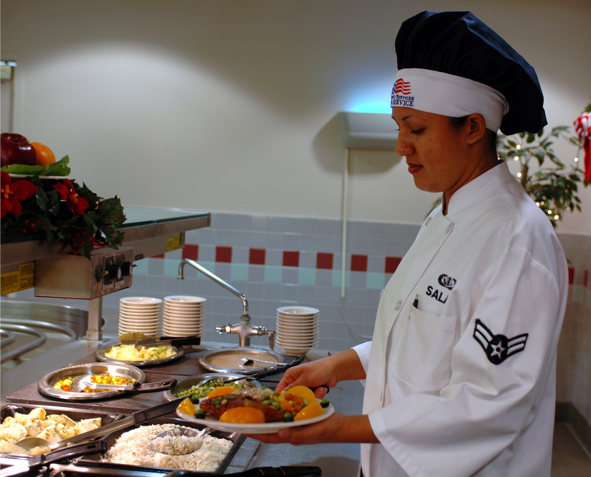 Airman 1st Class Irene Salas, 60th Services Squadron, serves lunch at the Sierra Inn Dining Facility Dec. 5. She was named an outstanding performer during the AMC Hennessy Award inspection in October. (U.S. Air Force photo by Tech. Sgt. Donald Osborn/ 60th Air Mobility Wing Public Affairs)